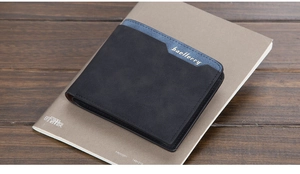 Close-up of slim matte leather men's bifold wallet with contrast blue stitching detail