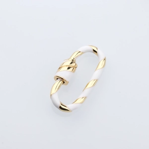 Macro shot of oval gold spiral screw clasp with white enamel finish jewelry detail