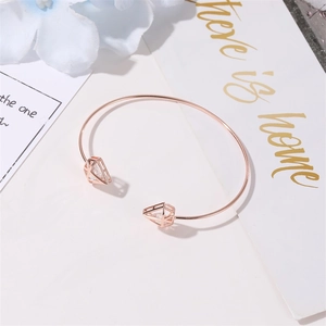Close-up of rose gold hollow triangle bracelet with zircons on a white background