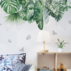 Tropical monstera and palm leaf wall stickers in a bright modern living room setting