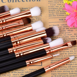 Detailed view of 12 rose gold eye makeup brushes set on a vintage newspaper background