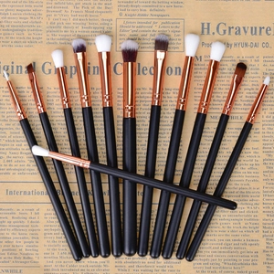 Close-up of 13-piece rose gold and black makeup brush set on vintage newspaper background