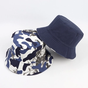 Détail d'un chapeau bob réversible montrant le côté bleu marine et le motif camouflage