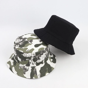 Détail d'un bob réversible camouflage et noir montrant la texture du tissu et les coutures