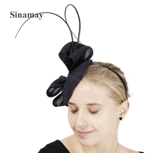 Detailed view of deep blue Sinamay fascinator with feather bow on a female model
