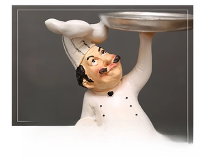 Detail of hand-painted resin chef statue holding a silver tray for home decor