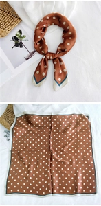 Detail of a brown silk square scarf with white polka dots and teal rolled edges