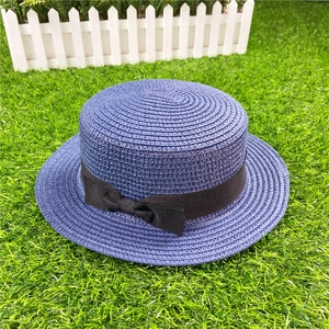 Close-up of blue-purple woven boater hat featuring a stylish black ribbon bow detail