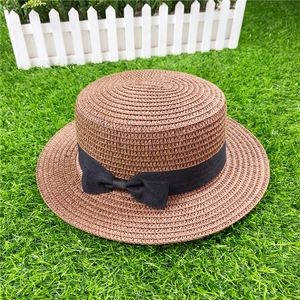 Detailed macro view of woven boater hat texture with black grosgrain ribbon bow