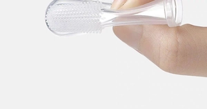 Close-up of transparent silicone finger toothbrush with soft bristles for baby oral care