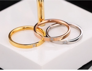 Nahaufnahme von minimalistischen Gold-, Silber- und Roségoldringen mit quadratischem Stein