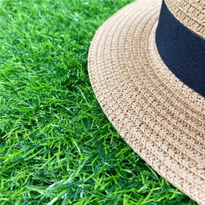 Close-up of fine weave texture and black grosgrain ribbon on a straw boater hat