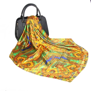 Vintage golden paisley print 90x90cm satin silk scarf displayed with a black handbag