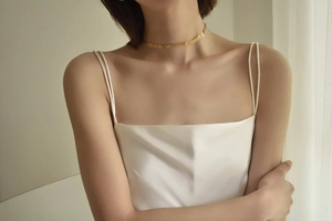 Close-up of a gold leaf choker necklace featuring elegant V-shaped sequin links
