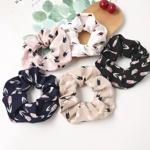 Set of five floral scrunchies with tulip patterns in pastel colors on wooden tray