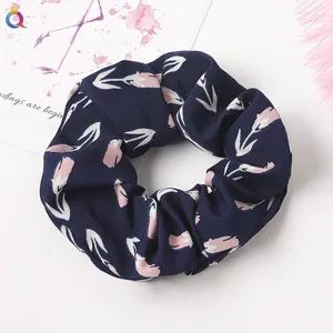 Detail of navy blue floral scrunchie with pink tulips and elastic pleated fabric texture