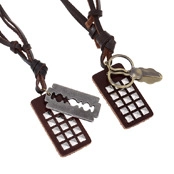 Detail of dark brown leather necklaces with vintage metal razor and scissors pendants