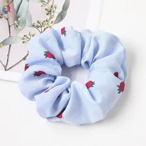 Detail of light blue strawberry print scrunchie with soft chiffon fabric texture