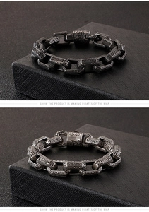 Detail of vintage punk men's stainless steel bracelet with intricate engraved patterns