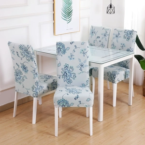 Detail of four blue and white floral printed elastic chair covers in a dining room