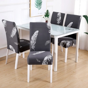Detail of grey elastic chair cover with white feather print on a dining chair