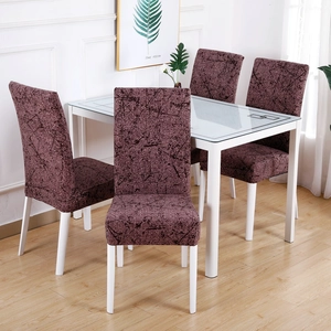 Dining room setup showing four chairs with elastic dark burgundy branch pattern covers