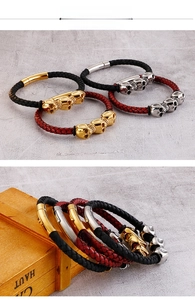 Detail of woven leather bracelets with skull charms and cylindrical magnetic clasps