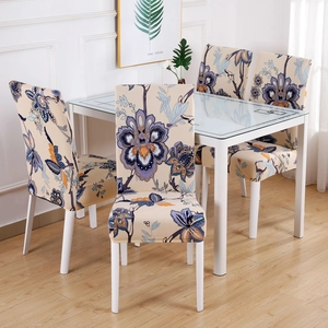 Dining room setting with four chairs in floral stretch covers around a glass table