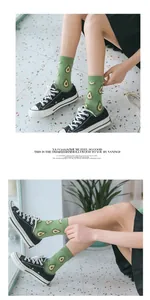 Close-up of green cotton crew socks featuring cute avocado prints and ribbed cuffs