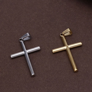 Polished gold and silver stainless steel cross pendants on a dark textured background