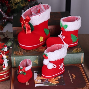 Close-up of red flocked Christmas boots with bells and bows on vintage books