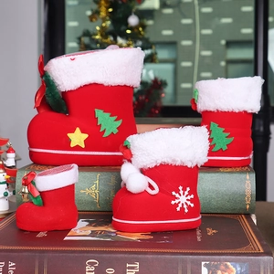 Detail of red flocked Christmas boots with festive tree patterns and white fur trim