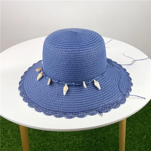 Chapeau de paille bleu foncé avec breloques coquillages et bord ondulé pour la plage