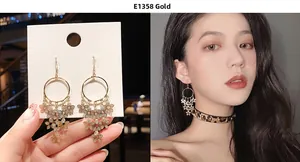 Detail of gold layered flower tassel earrings with rhinestones shown on model