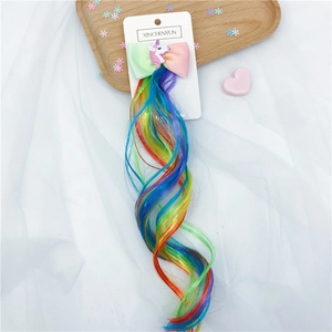 Close-up of unicorn hair clips with rainbow extensions on a wooden display tray
