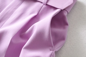 Detalle de los pantalones morado claro mostrando costuras de bolsillos y textura de tela