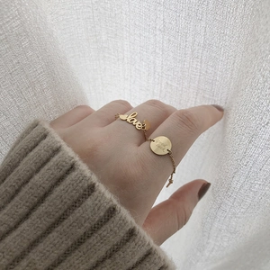 Detail of adjustable chain ring with gold heart and good luck engraved charms