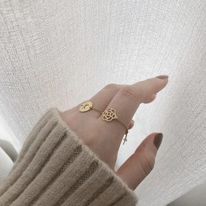 Detail of 14K gold-plated titanium steel bracelet with K-letter and camellia flower charms