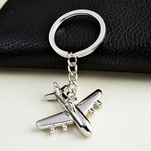 Close-up of a silver metal fighter jet keychain with a polished finish and a link chain