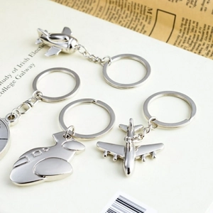 Detailed view of silver metal J-20 fighter jet airplane keychains on a vintage background