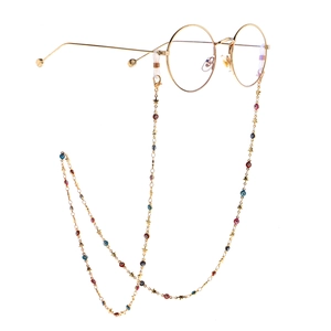 Golden round glasses with evil eye and star charms chain on a white background