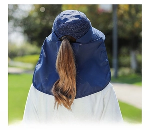 Dettaglio del cappello da sole blu navy con foro per coda di cavallo e protezione collo