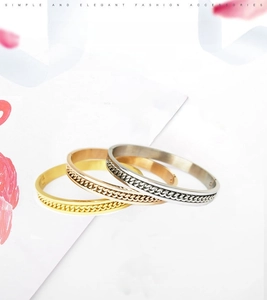 Detailed view of stackable chain bracelets in gold, rose gold, and silver finishes
