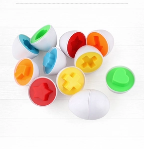Flat lay of colorful geometric shape matching toy eggs on a white wood background