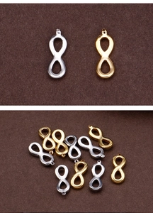 Macro detail of figure-eight infinity pendants in gold and silver stainless steel