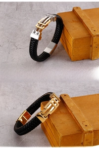 Detail of woven black leather bracelet featuring a gold and silver geometric metal clasp