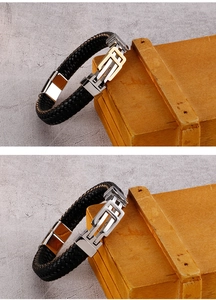 Detail of woven leather bracelets with silver and gold stainless steel clasps on wood
