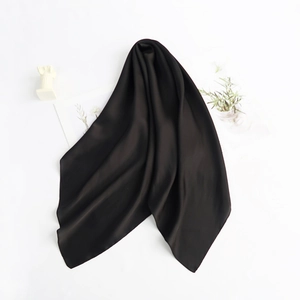 Close-up of a premium black silk scarf with a smooth, glossy texture on a white background