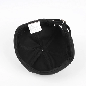 Detail view of cotton docker hat interior with adjustable metal buckle and size label