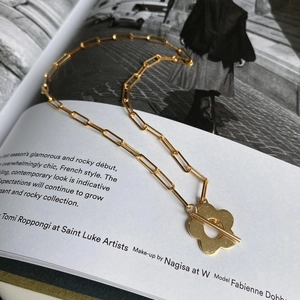 Detail view of a 925 sterling silver flower T-bar chain necklace on a fashion magazine